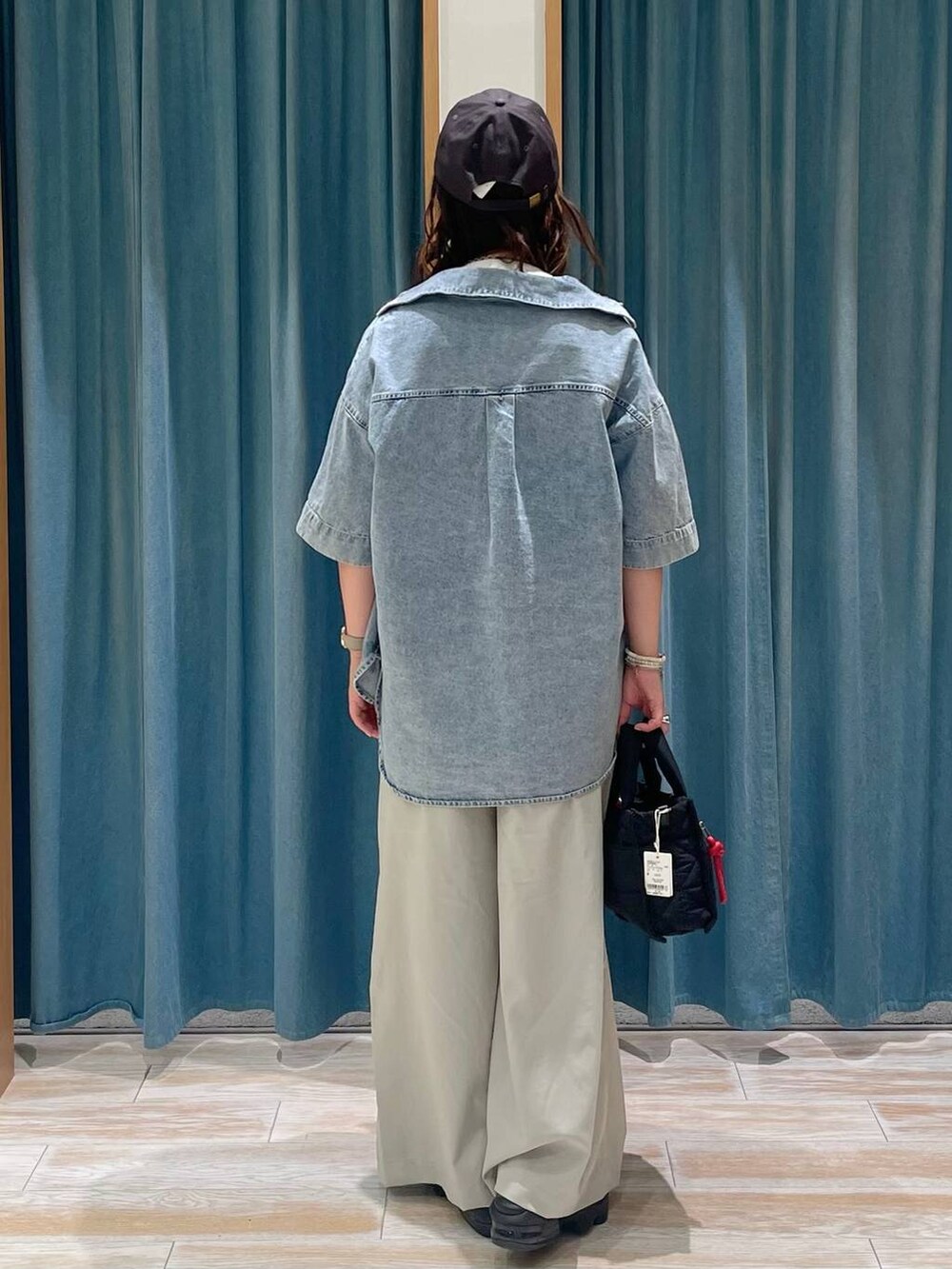 ベージュ系のその他パンツ、ブラック系のショルダーバッグ、ホワイト系のTシャツ/カットソーを着用したレディースの夏コーディネートの3枚目の写真