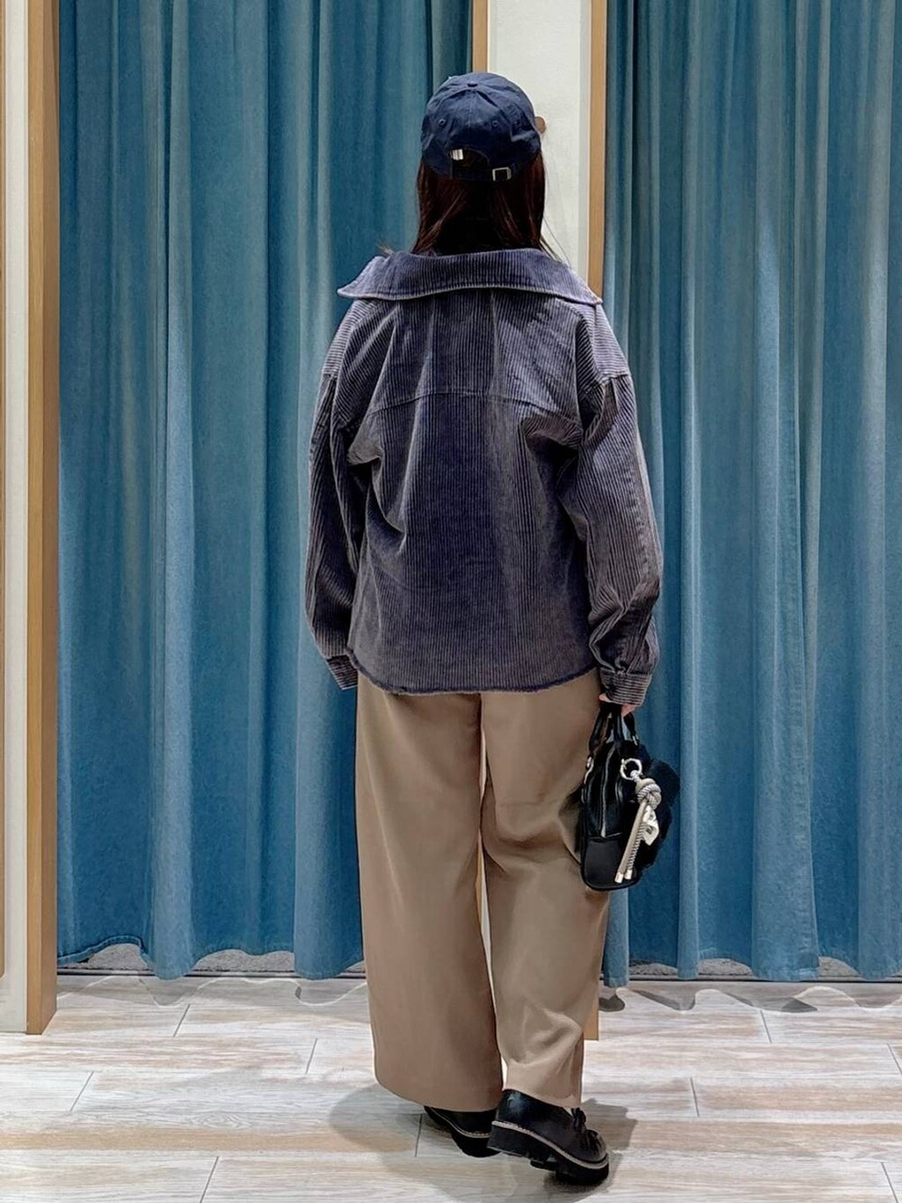 ブラック系のTシャツ/カットソー、ブラック系のボストンバッグ、ブラック系のローファーを着用したレディースの秋コーディネートの3枚目の写真