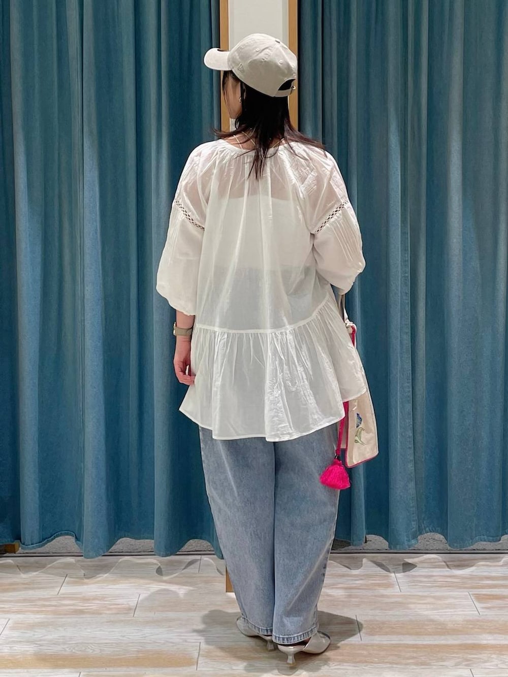 ホワイト系のキャミソール、ブルー系のデニムパンツ、シルバー系のサンダルを着用したレディースの春コーディネートの3枚目の写真