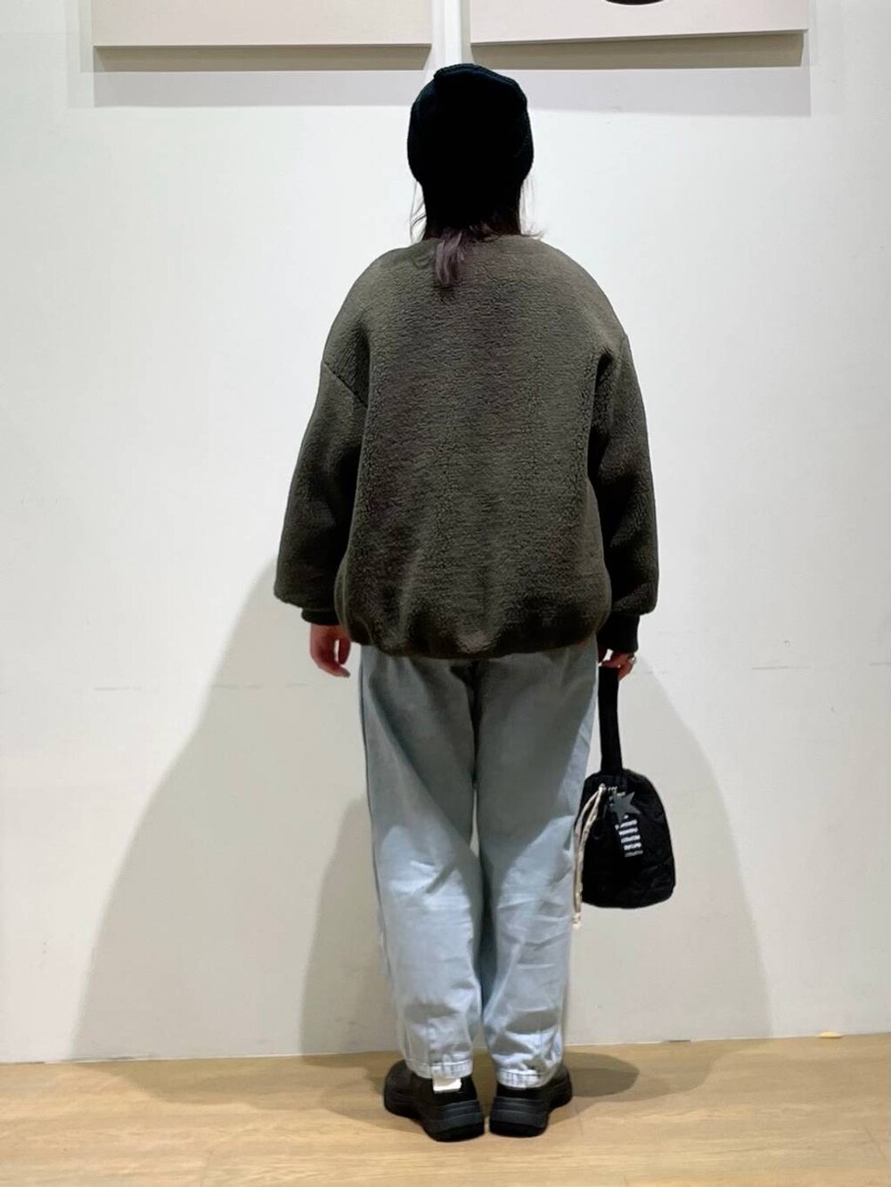 グリーン系のブルゾン、ブラック系のブーツ、ブラック系のショルダーバッグを着用したレディースの秋コーディネートの3枚目の写真