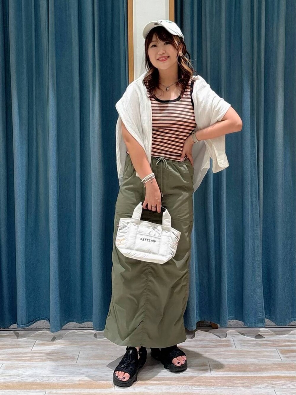 ホワイト系のシャツ/ブラウス、グリーン系のスカート、ホワイト系のトートバッグを着用したレディースの夏コーディネートの4枚目の写真