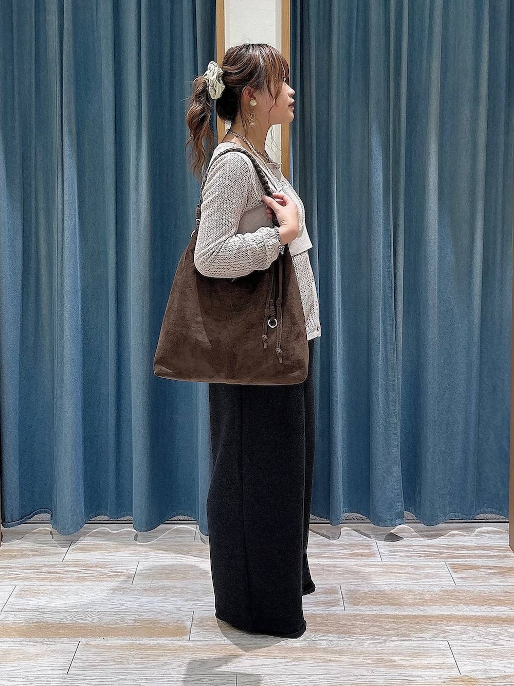 ブラック系のスリッポン、ベージュ系のニット/セーター、グレー系のスウェットパンツを着用したレディースの秋コーディネートの2枚目の写真
