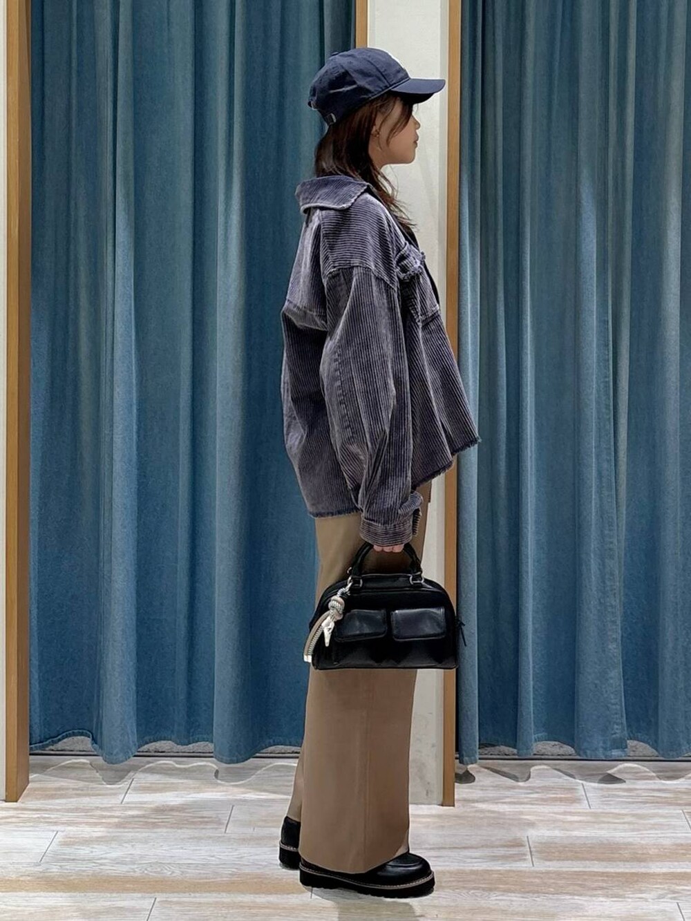 ブラック系のTシャツ/カットソー、ブラック系のボストンバッグ、ブラック系のローファーを着用したレディースの秋コーディネートの2枚目の写真