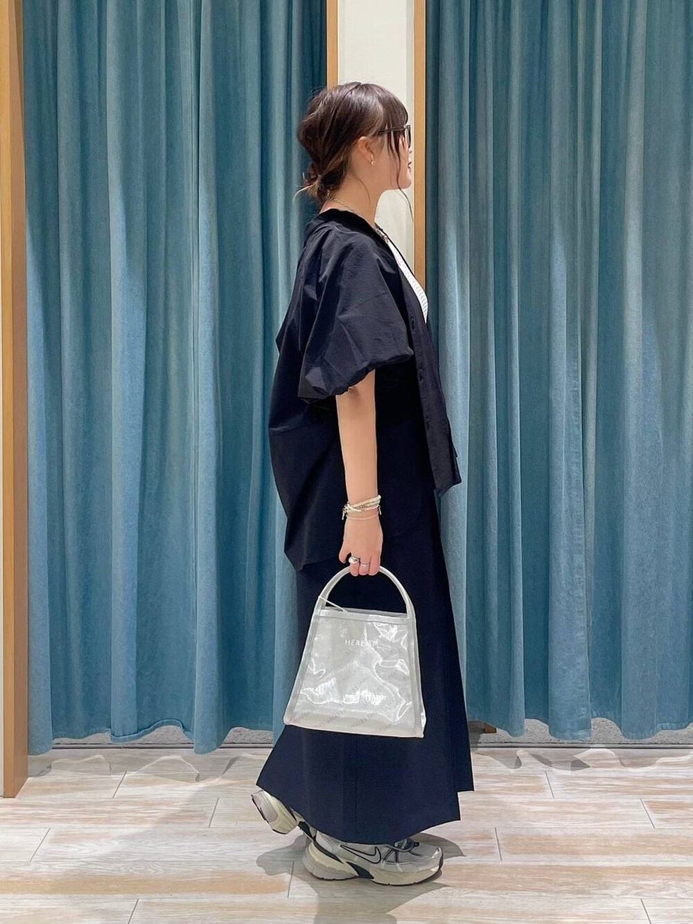 ホワイト系のキャミソール、シルバー系のハンドバッグ、ブラック系のシャツ/ブラウスを着用したレディースの春コーディネートの2枚目の写真