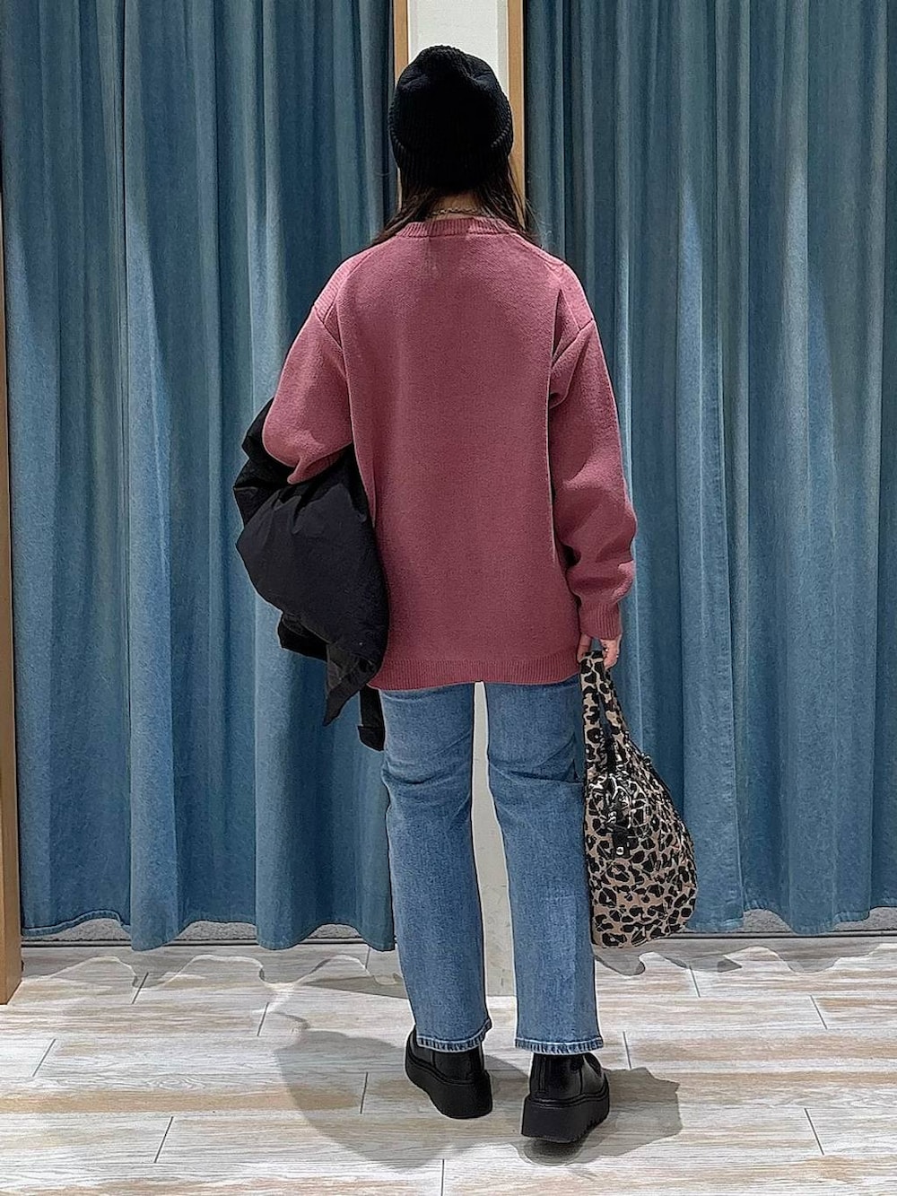 ブラック系のブーツ、ブラック系のダウンジャケット/コート、ピンク系のニット/セーターを着用したレディースの冬コーディネートの3枚目の写真