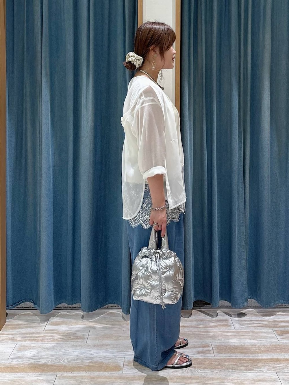 ブルー系のデニムパンツ、シルバー系のショルダーバッグ、シルバー系のサンダルを着用したレディースの春コーディネートの2枚目の写真