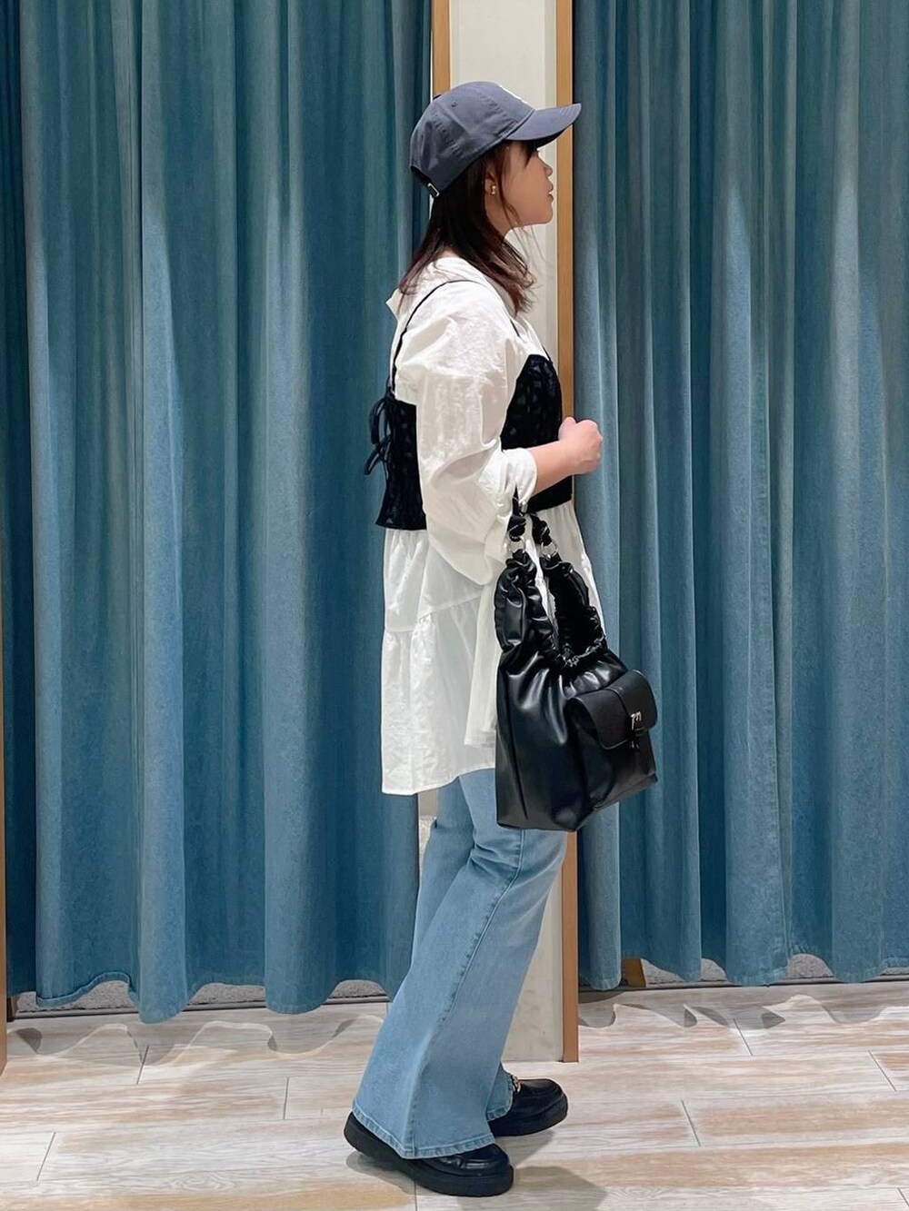 ブルー系のデニムパンツ、ブラック系のキャミソール、ブラック系のハンドバッグを着用したレディースの春コーディネートの2枚目の写真