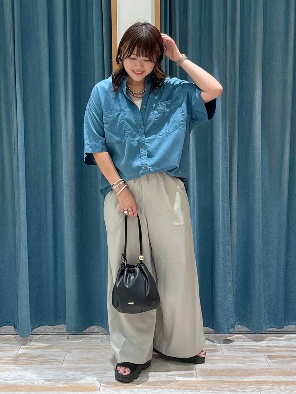 ホワイト系のキャミソール、ブルー系のシャツ/ブラウス、ベージュ系のその他パンツを着用したレディースの夏コーディネートの4枚目の写真