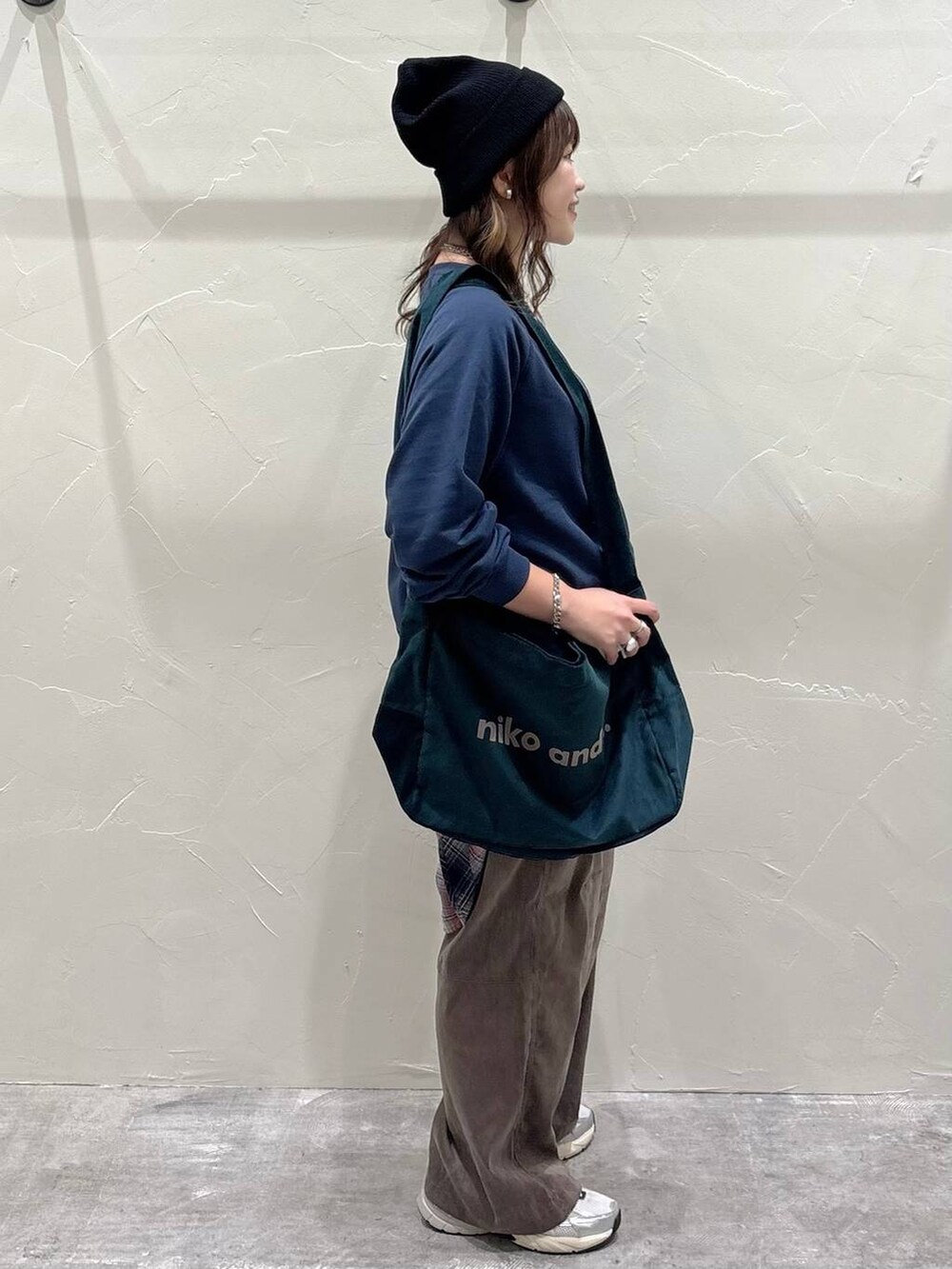 オレンジ系のシャツ/ブラウス、グリーン系のショルダーバッグ、ブラック系のニットキャップ/ビーニーを着用したレディースの秋コーディネートの2枚目の写真