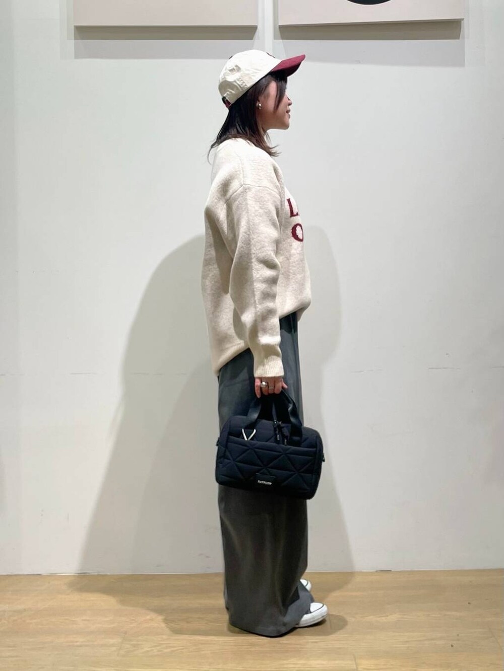 グレー系のその他パンツ、ブラック系のハンドバッグ、ホワイト系のニット/セーターを着用したレディースの秋コーディネートの2枚目の写真