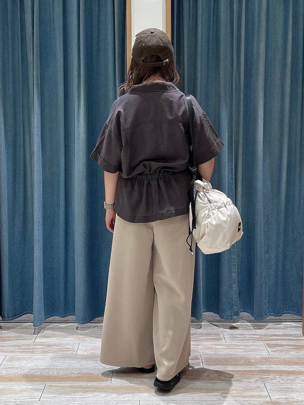 ホワイト系のトートバッグ、グレー系のシャツ/ブラウス、ブラック系のサンダルを着用したレディースの夏コーディネートの3枚目の写真