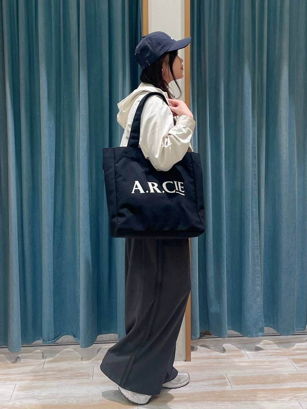 ホワイト系のマウンテンパーカー、グレー系のその他パンツ、ブルー系のTシャツ/カットソーを着用したレディースの春コーディネートの2枚目の写真