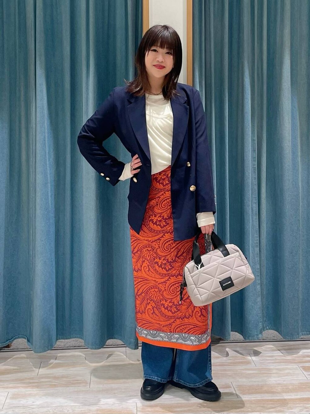 ブルー系のテーラードジャケット、ベージュ系のハンドバッグ、その他のローファーを着用したレディースの春コーディネートの4枚目の写真