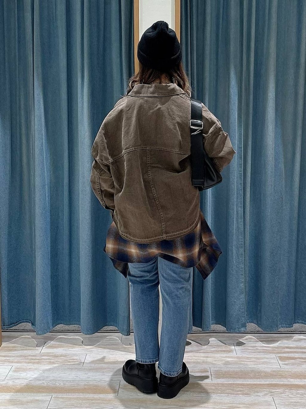 ブラック系のブーツ、ブルー系のデニムパンツ、ベージュ系のスウェットを着用したレディースの冬コーディネートの3枚目の写真