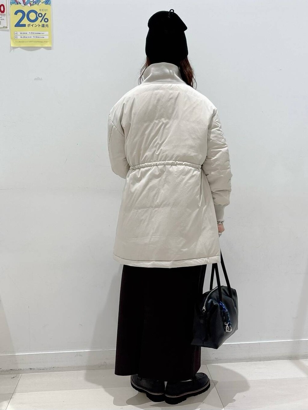 ベージュ系のダウンジャケット/コート、ブラック系のボストンバッグ、ブラック系のローファーを着用したレディースの秋コーディネートの3枚目の写真