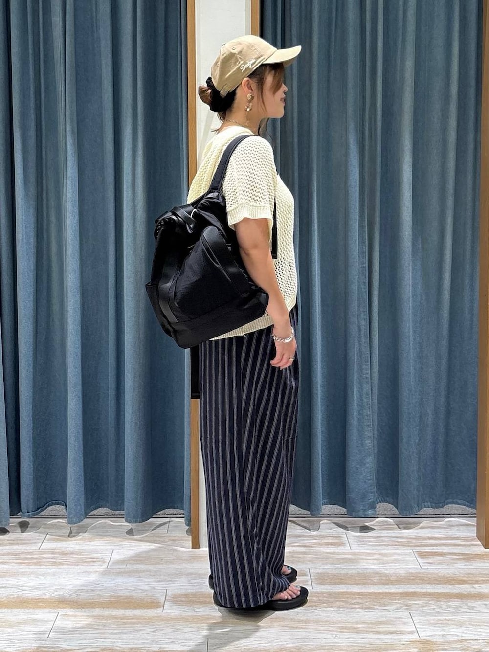 ブラック系のバックパック/リュック、ブルー系のその他パンツ、ブラック系のサンダルを着用したレディースの夏コーディネートの2枚目の写真