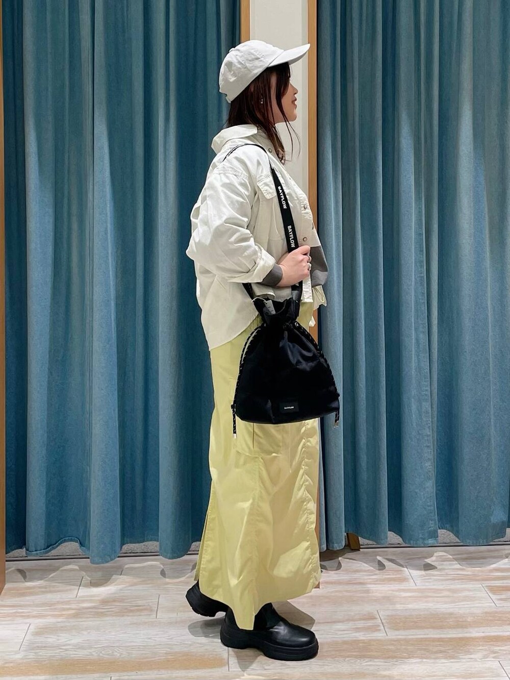 ブラック系のブーツ、ブラック系のショルダーバッグ、ホワイト系のシャツ/ブラウスを着用したレディースの冬コーディネートの2枚目の写真