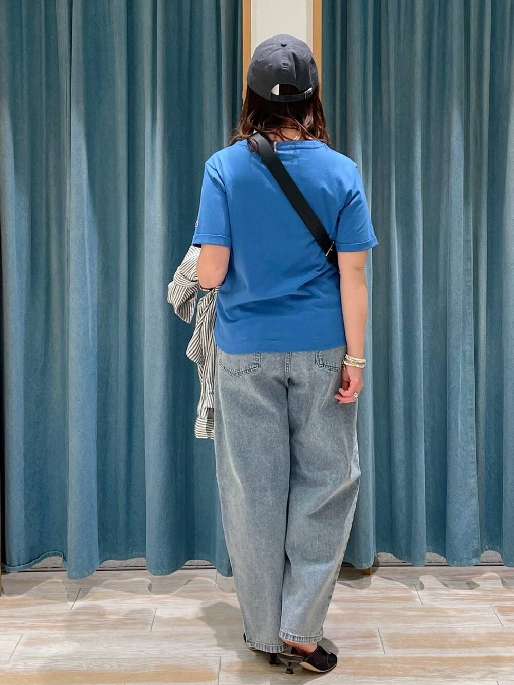 ブルー系のデニムパンツ、ブルー系のシャツ/ブラウス、ブラック系のサンダルを着用したレディースの春コーディネートの3枚目の写真