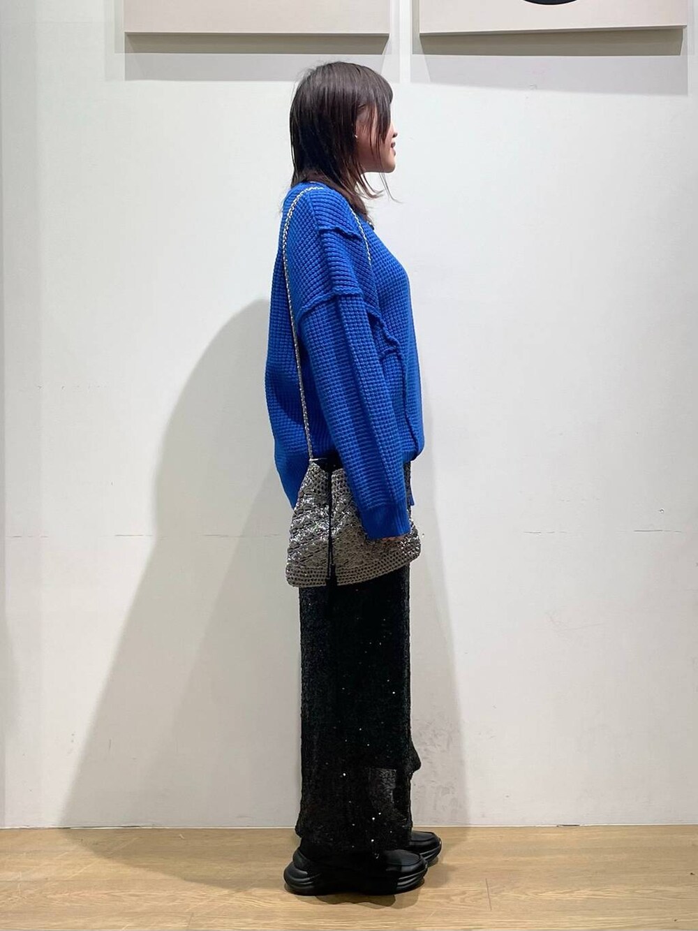 ブラック系のローファー、シルバー系のショルダーバッグ、ブラック系のスカートを着用したレディースの秋コーディネートの2枚目の写真