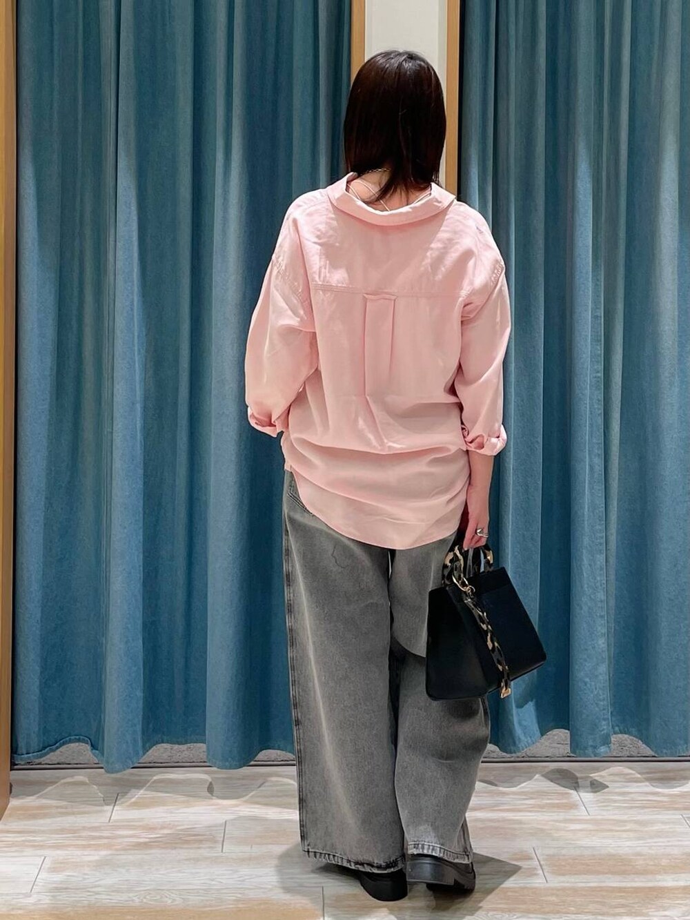 ブラック系のハンドバッグ、グレー系のデニムパンツ、その他のローファーを着用したレディースの冬コーディネートの3枚目の写真