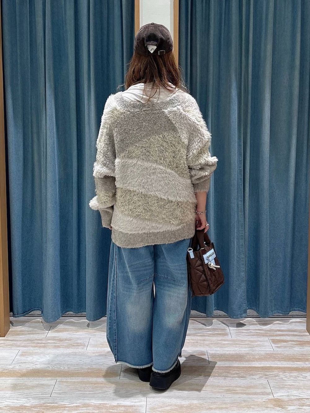ベージュ系のカーディガン/ボレロ、ブルー系のデニムパンツ、ブラウン系のショルダーバッグを着用したレディースの秋コーディネートの2枚目の写真