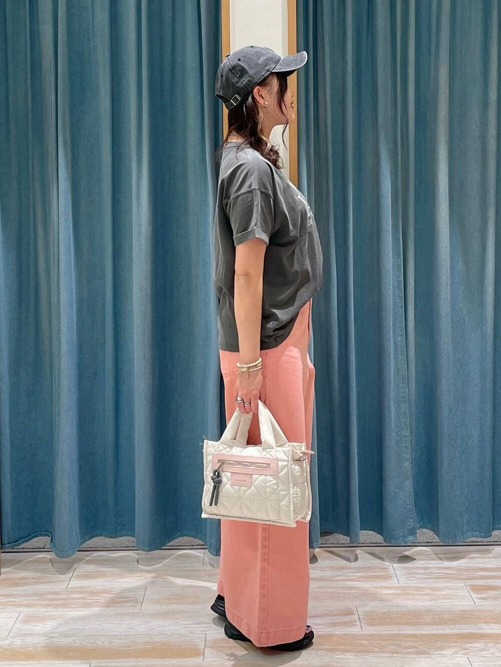 グレー系のTシャツ/カットソー、ホワイト系のショルダーバッグ、ピンク系のデニムパンツを着用したレディースの春コーディネートの2枚目の写真