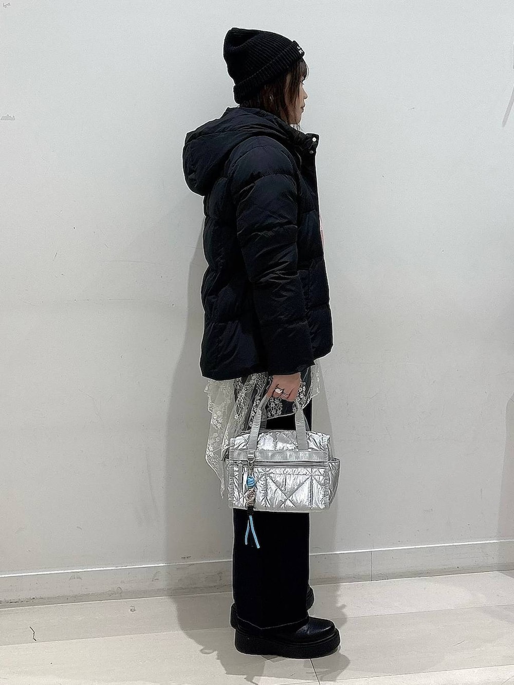 ブラック系のダウンジャケット/コート、ブルー系のデニムパンツ、シルバー系のボストンバッグを着用したレディースの冬コーディネートの2枚目の写真