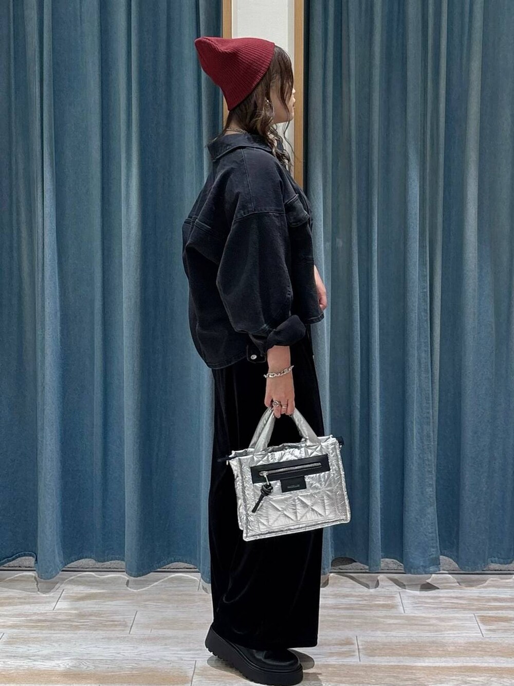 ブラック系のキャミソール、シルバー系のショルダーバッグ、ブラック系のブーツを着用したレディースの秋コーディネートの2枚目の写真