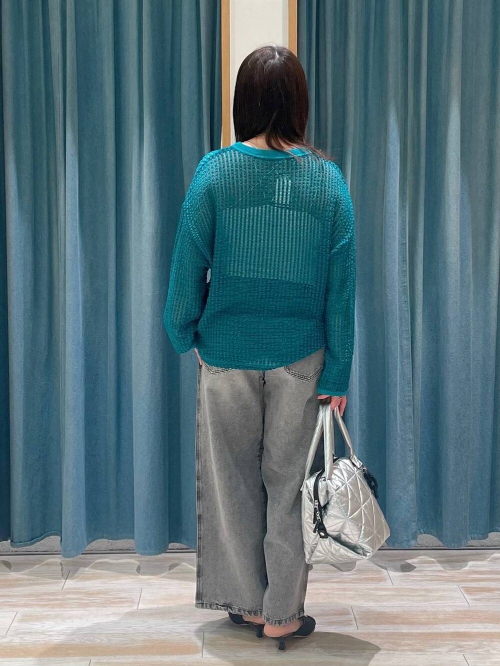 グレー系のデニムパンツ、ブラック系のサンダル、グリーン系のTシャツ/カットソーを着用したレディースの春コーディネートの3枚目の写真