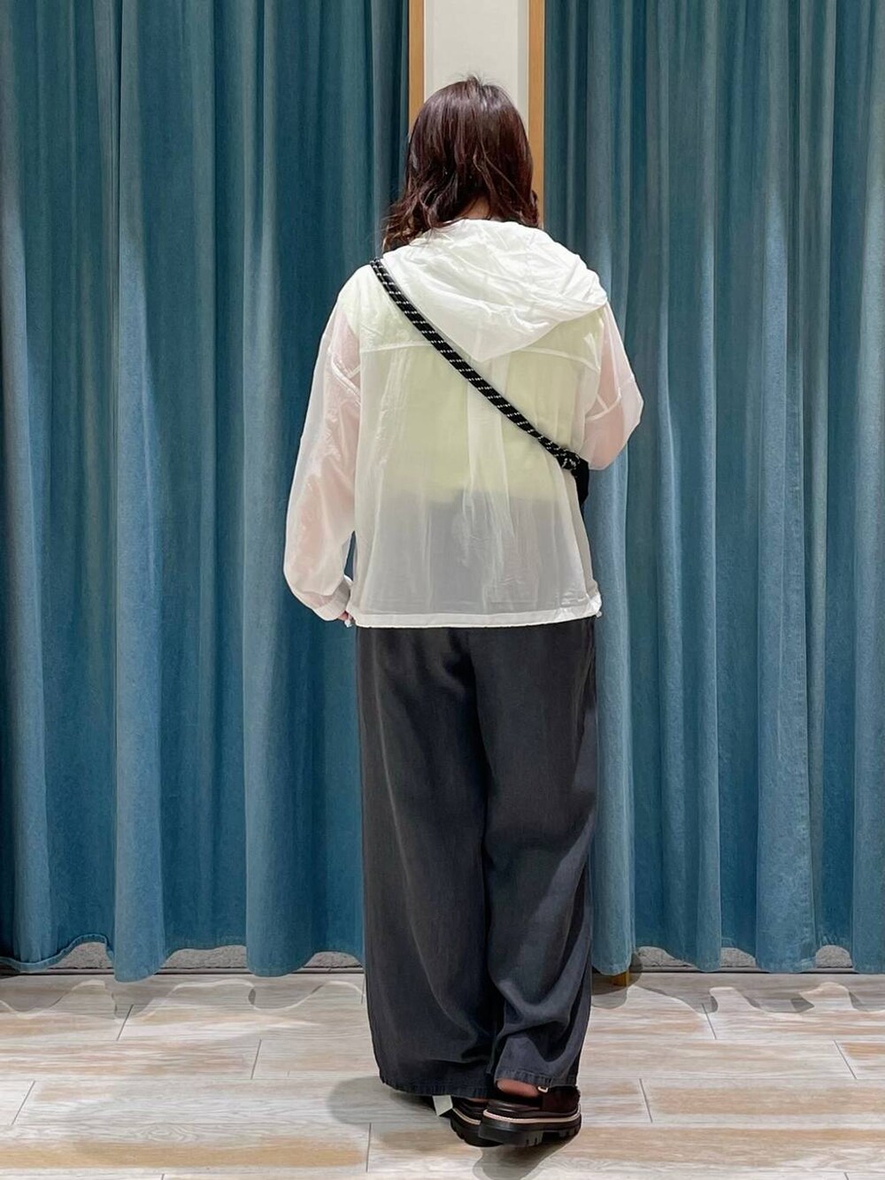 ブラウン系のサンダル、ブラック系のその他パンツ、ホワイト系のナイロンジャケットを着用したレディースの春コーディネートの3枚目の写真