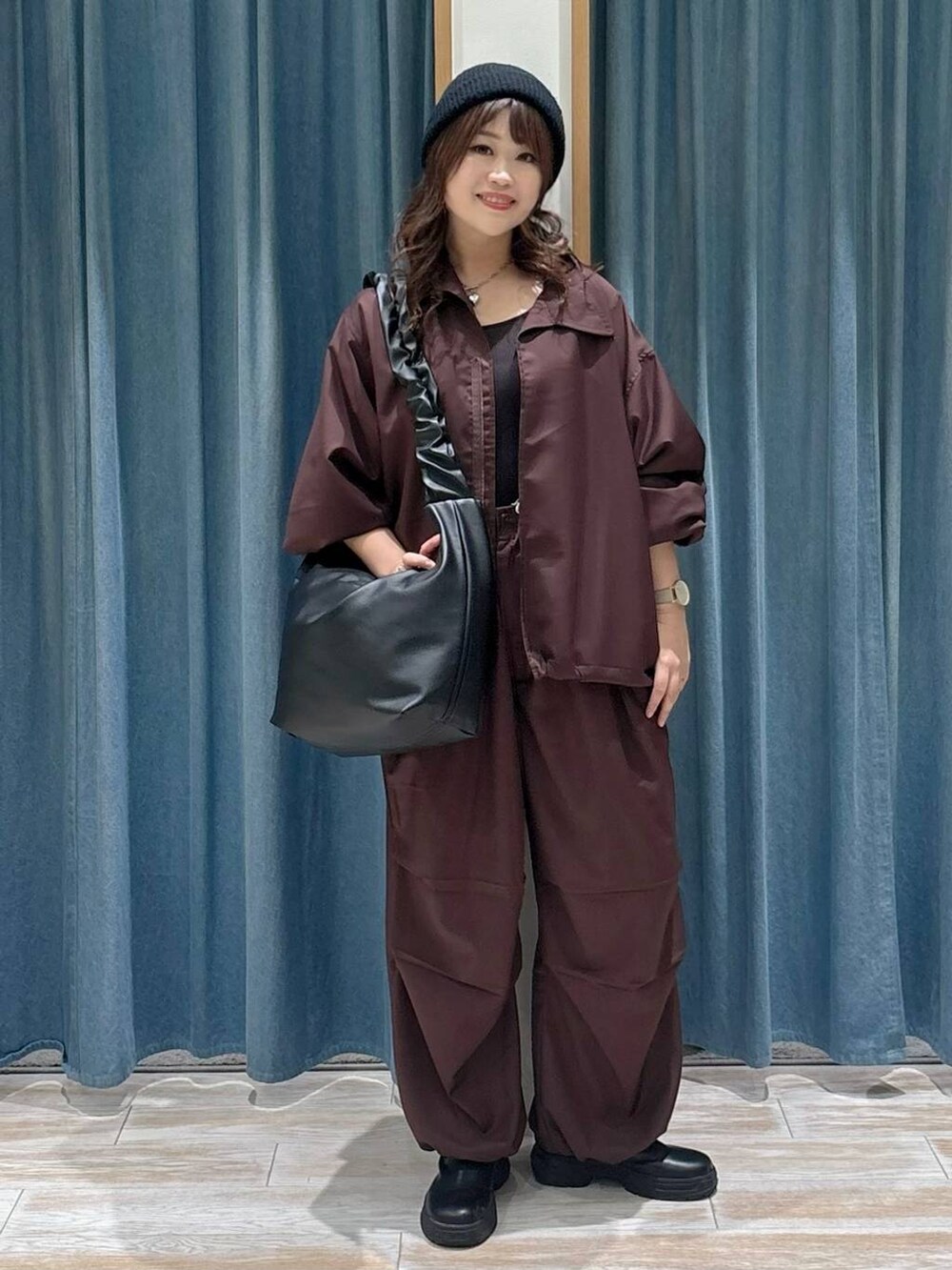 ブラック系のブーツ、ブラック系のショルダーバッグ、グレー系のネックレスを着用したレディースの秋コーディネートの4枚目の写真