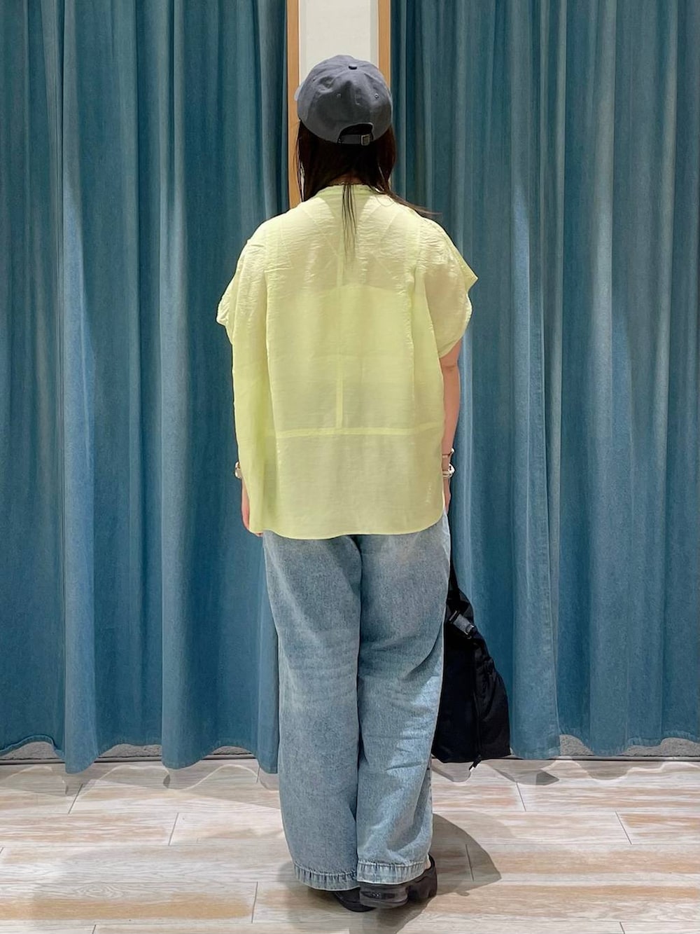 ホワイト系のキャミソール、ブラック系のトートバッグ、イエロー系のシャツ/ブラウスを着用したレディースの春コーディネートの3枚目の写真