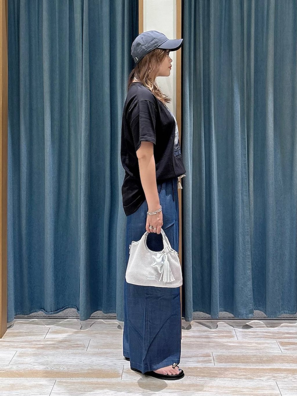 ブルー系のデニムパンツ、グレー系のショルダーバッグ、ブラック系のサンダルを着用したレディースの夏コーディネートの2枚目の写真