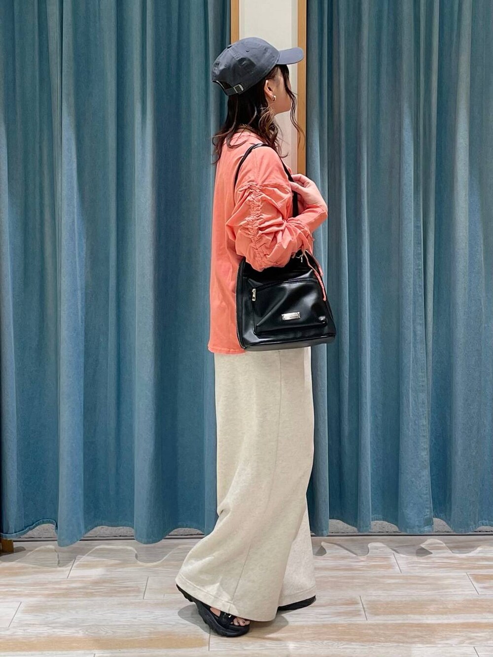 ベージュ系のスウェットパンツ、ブラック系のサンダル、ブラック系のバックパック/リュックを着用したレディースの春コーディネートの2枚目の写真