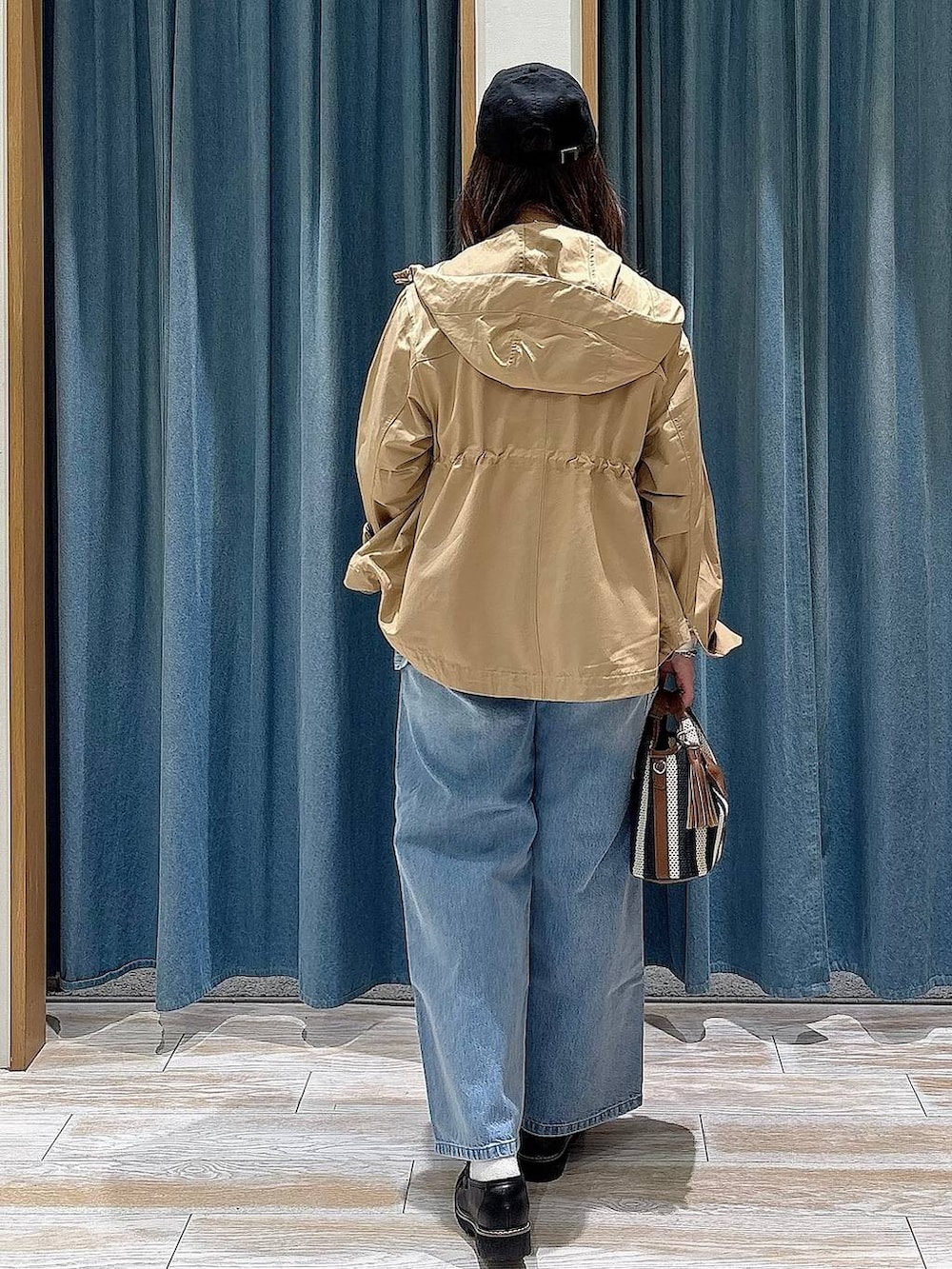 ホワイト系のTシャツ/カットソー、イエロー系のマウンテンパーカー、ブルー系のデニムパンツを着用したレディースの春コーディネートの3枚目の写真