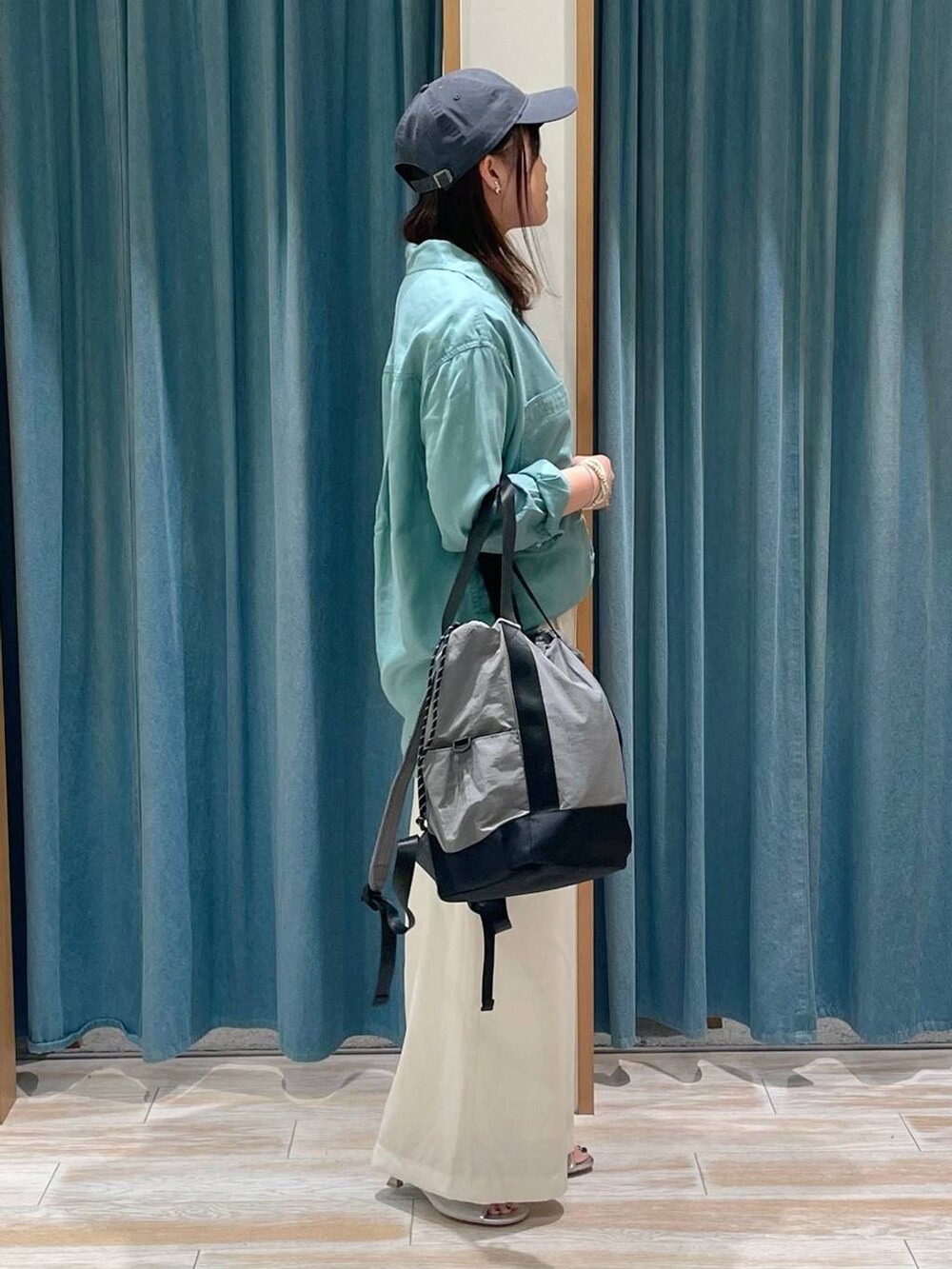 グリーン系のシャツ/ブラウス、ホワイト系のその他パンツ、グレー系のバックパック/リュックを着用したレディースの春コーディネートの2枚目の写真