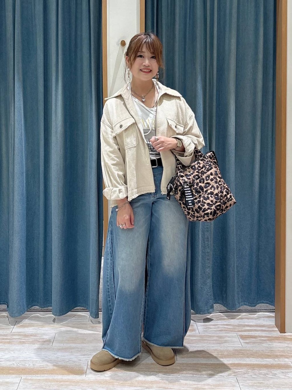ホワイト系のブルゾン、ベージュ系のその他シューズ、ブルー系のデニムパンツを着用したレディースの秋コーディネートの4枚目の写真
