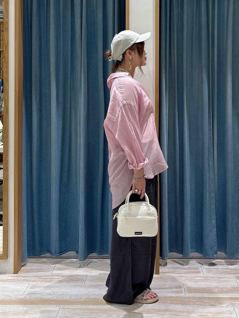 ピンク系のシャツ/ブラウス、ブラック系のデニムパンツ、ホワイト系のハンドバッグを着用したレディースの夏コーディネートの2枚目の写真