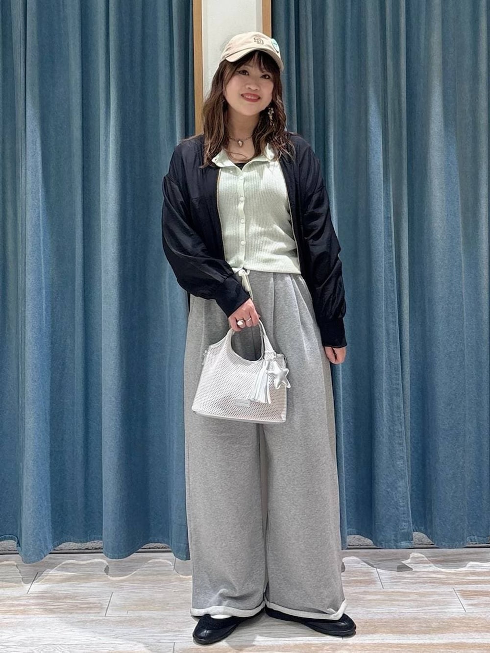 ブラック系のバレエシューズ、グレー系のショルダーバッグ、グリーン系のカーディガン/ボレロを着用したレディースの春コーディネートの3枚目の写真