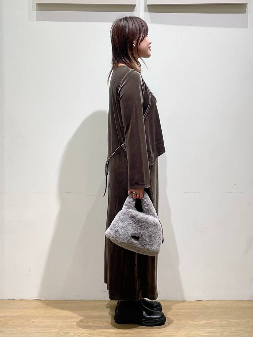 ブラック系のブーツ、グレー系のショルダーバッグ、グリーン系のワンピースを着用したレディースの秋コーディネートの2枚目の写真