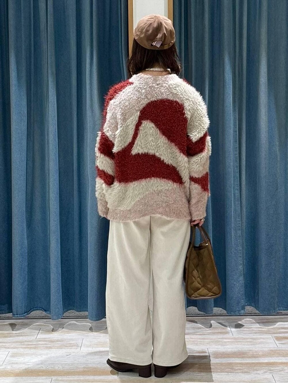 ブラウン系のブーツ、レッド系のカーディガン/ボレロ、イエロー系のハンドバッグを着用したレディースの秋コーディネートの3枚目の写真