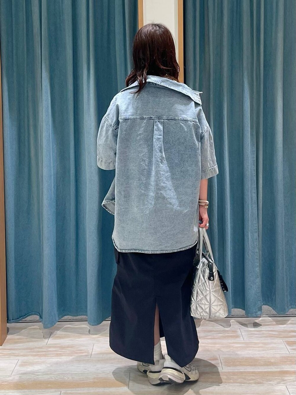 ベージュ系のTシャツ/カットソー、シルバー系のトートバッグ、ブラック系のスカートを着用したレディースの春コーディネートの3枚目の写真