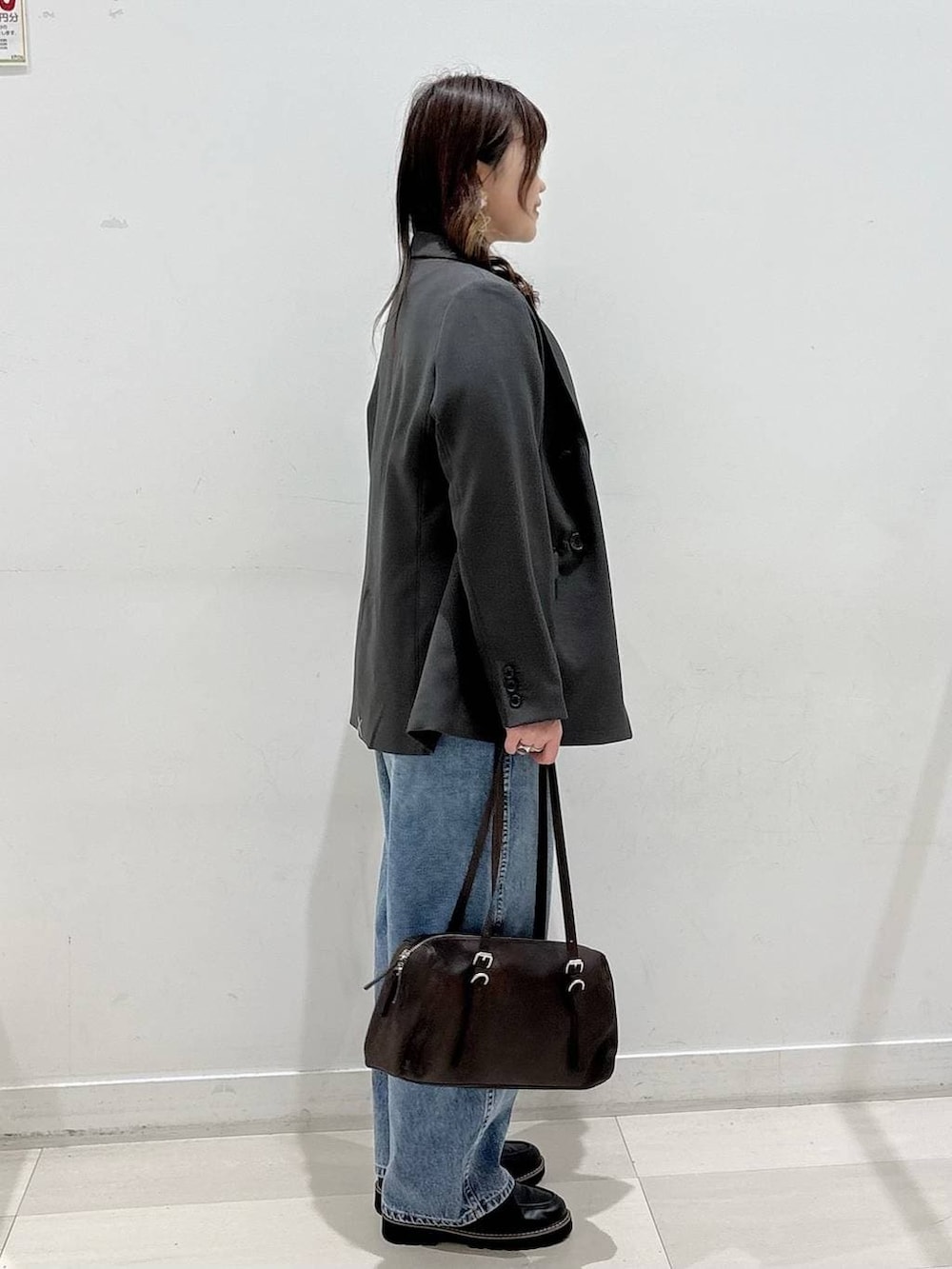 ブラック系のTシャツ/カットソー、ブルー系のデニムパンツ、グレー系のテーラードジャケットを着用したレディースの冬コーディネートの2枚目の写真