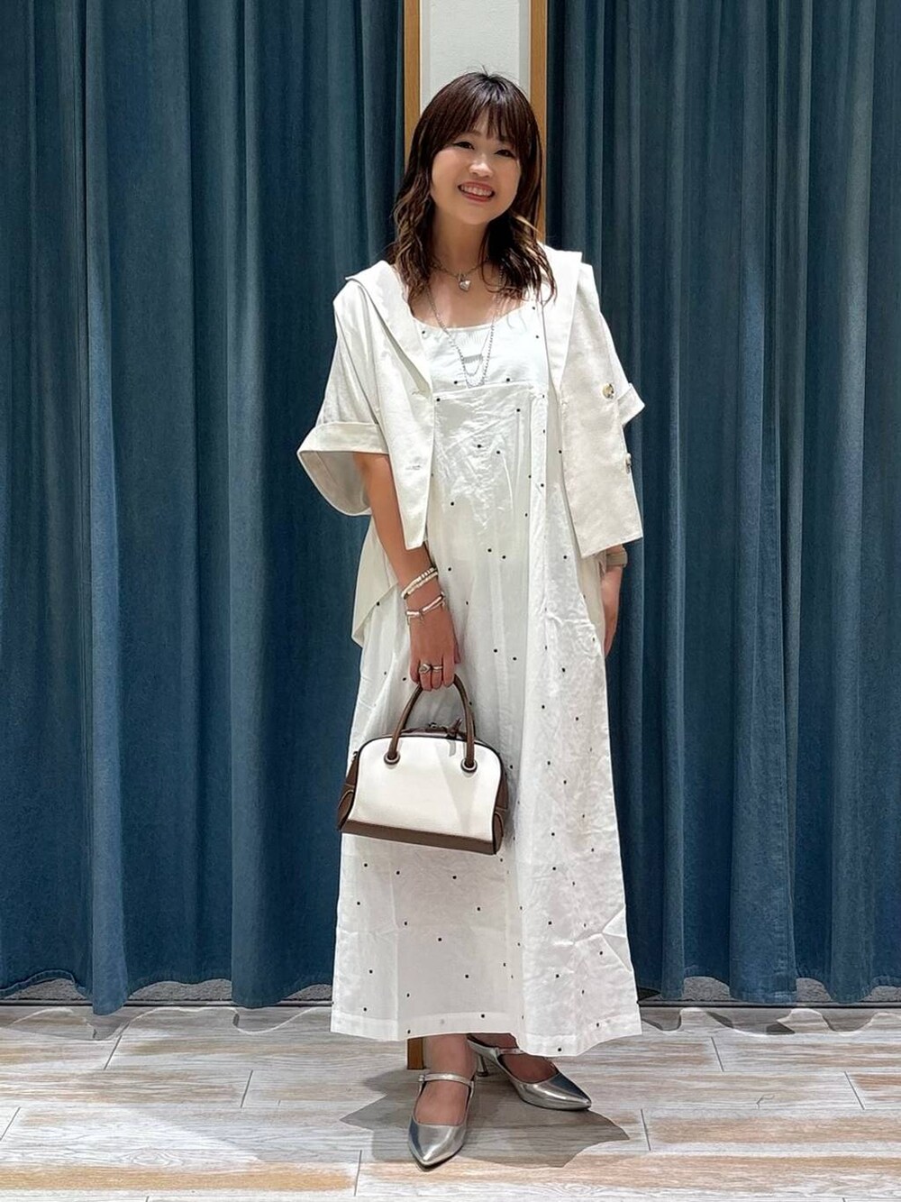 シルバー系のパンプス、ホワイト系のキャミソール、ベージュ系のその他アウターを着用したレディースの夏コーディネートの3枚目の写真