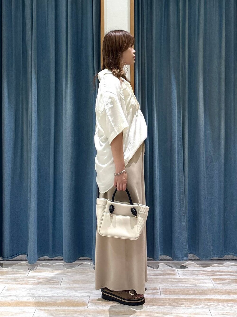 ホワイト系のシャツ/ブラウス、ベージュ系のサンダル、ベージュ系のショルダーバッグを着用したレディースの夏コーディネートの2枚目の写真