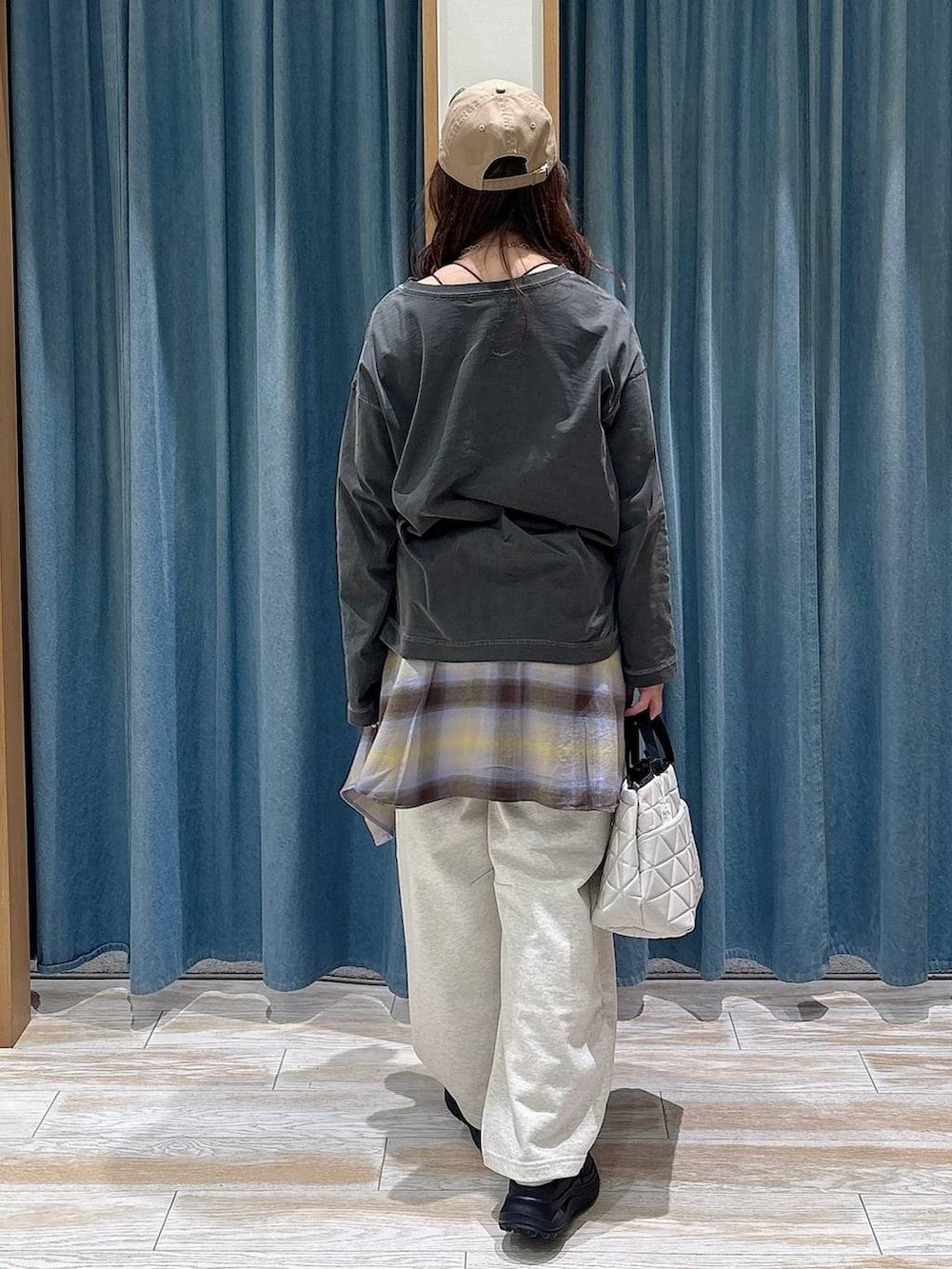 ベージュ系のトートバッグ、イエロー系のシャツ/ブラウス、グレー系のTシャツ/カットソーを着用したレディースの冬コーディネートの3枚目の写真