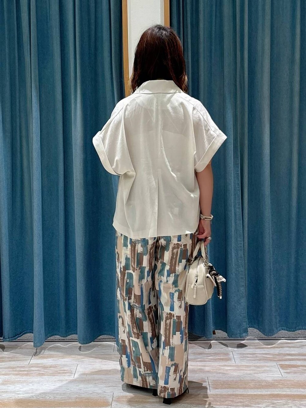 ホワイト系のキャミソール、ベージュ系のその他アウター、レッド系のその他シューズを着用したレディースの夏コーディネートの3枚目の写真