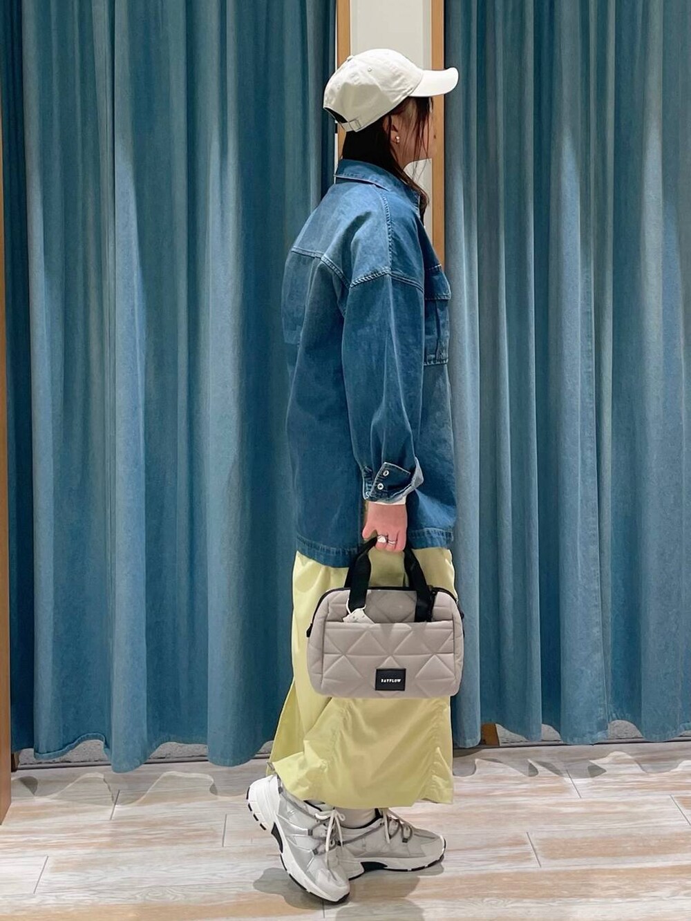 ホワイト系のTシャツ/カットソー、ベージュ系のハンドバッグ、ホワイト系のスニーカーを着用したレディースの春コーディネートの2枚目の写真