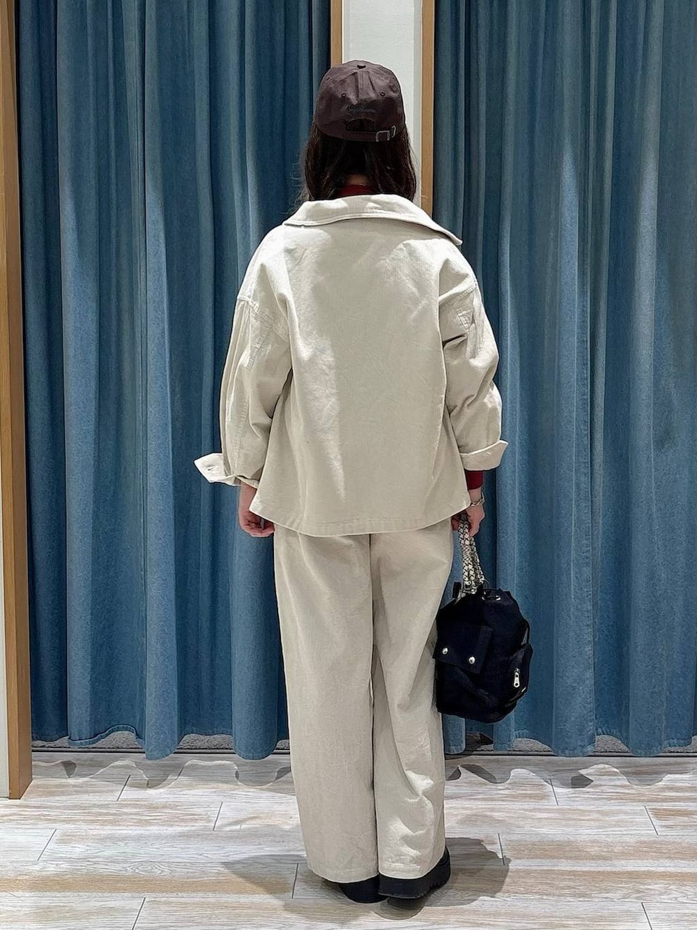 ブラック系のブーツ、ブラック系のハンドバッグ、レッド系のスウェットを着用したレディースの冬コーディネートの3枚目の写真