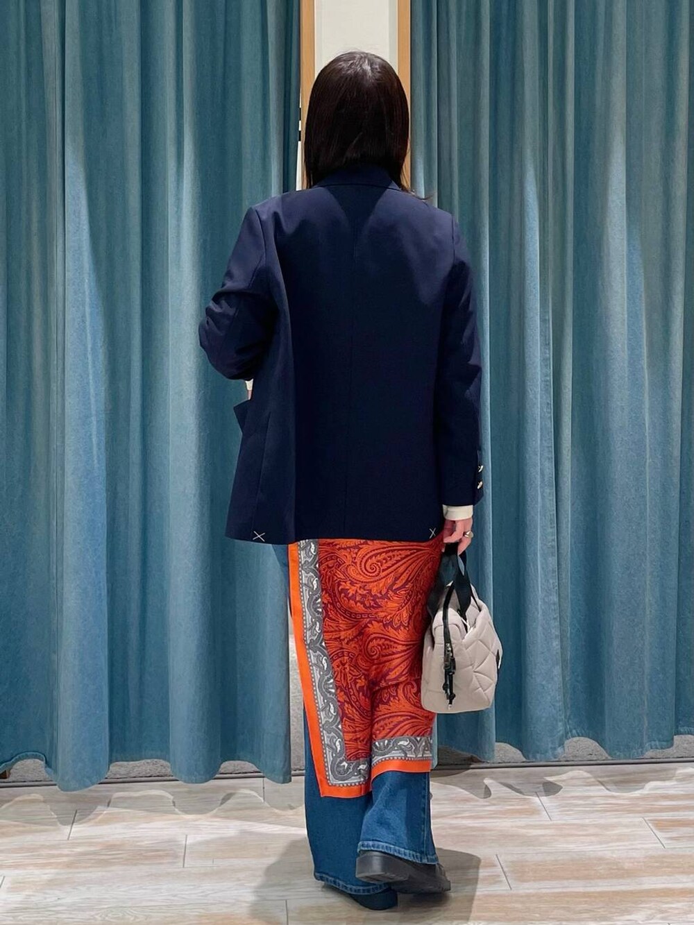 ブルー系のテーラードジャケット、ベージュ系のハンドバッグ、その他のローファーを着用したレディースの春コーディネートの3枚目の写真